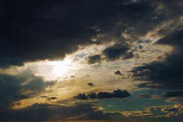 Fototapeta premium beautiful dramatic sky, bright sunlight and dark silhouette of clouds as background