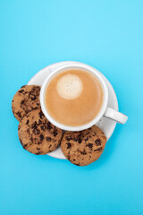a cup of coffee with cookies chocolate drops