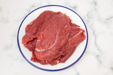 raw fresh meat with pepper on white dish