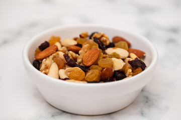 dry fruits in white small bowl on light gray