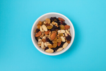 dry fruits in white small bowl on blue paper