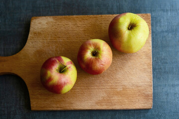Three apples on a cutting board