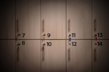 Many wooden lockers with keys and numbers on doors. Vignette effect