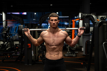 Naklejka premium Shirtless weightlifter man lifting barbell in gym, weightlifting