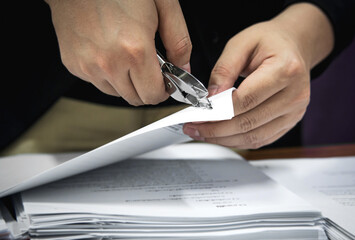 Man using a stapler puller to remove staples from a document. Office essential tools for paperwork
