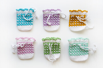 Knitted colored bags on a white background. Bags for Easter eggs. Handmade Banner