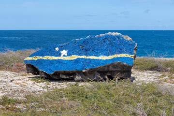 The flag of Curacao painted on a rock near the Watamula Hole on Curacao, island in the Caribbean