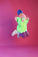 Cute indie girl jumping on violet background