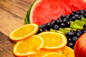 Fresh fruits concept, Colorful fruits of watermelon kiwi orange and blueberry on wooden background