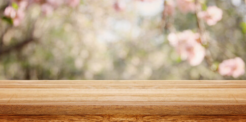 wooden table in front of spring blossom tree landscape. Product display and presentation