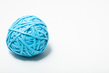 close up macro of a single blue ball of many rubber bands on a white background