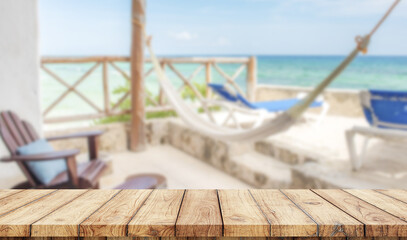 Empty wooden table with relaxing zone in the beach on background
