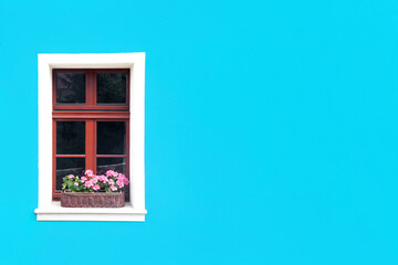 Window with flower box. Italian architecture background. Vibrant color blue wall facade. Small town house exterior. Street of European city building. Empty copy space wall.