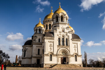 Fototapeta na wymiar Orthodox church with golden domes and crosses against a clear blue sky with clouds. view of the Ascension Cathedral in the town of Novocherkassk.Russia.
