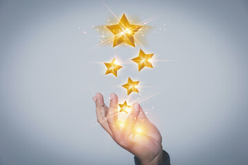 The Businessman hand showing virtual five yellow stars. Evaluation the customer satisfaction and...