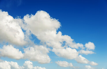 Naklejka na ściany i meble White fluffy clouds on blue sky