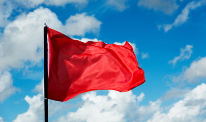 Red flag waving against blue sky