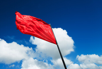 Red flag waving against blue sky