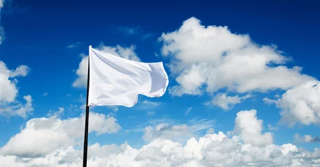 Fotobehang White flag flying against blue sky © xy
