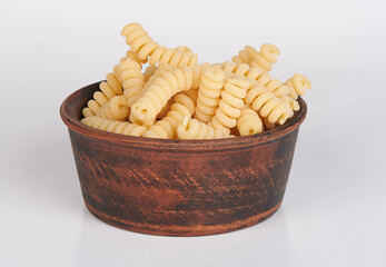 Raw Fusilli italian pasta in wooden bowl isolated