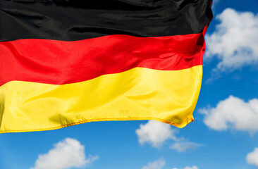 German flag waving against blue sky