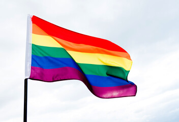 Rainbow flag waving on sky