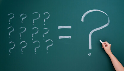 Question marks written on blackboard