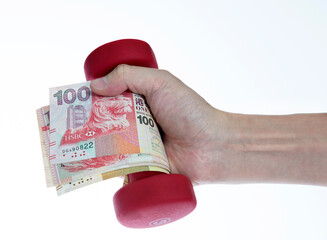 Hand holding red dumbbell covered money