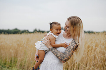 Mother embracing her adorable little girl in wheat fields