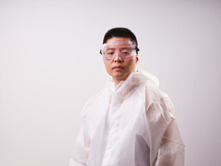 A health care worker wearing a mask and protective clothing on a solid color background