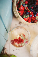 gros plan sur un verre de vin blanc frais avec des fruits rouges 