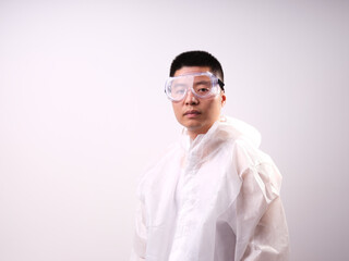 A health care worker wearing a mask and protective clothing on a solid color background