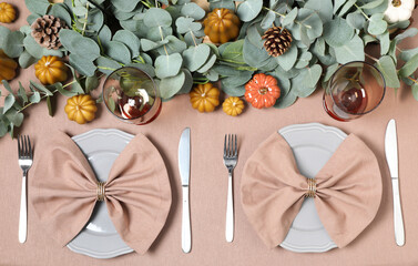 Autumn table setting with eucalyptus branches and pumpkins, flat lay