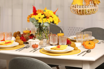Autumn table setting with floral decor and pumpkins indoors