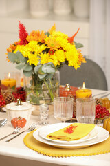 Naklejka na ściany i meble Autumn table setting with floral decor and pumpkins indoors