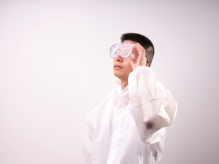 A health care worker wearing a mask and protective clothing on a solid color background