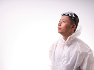 A health care worker wearing a mask and protective clothing on a solid color background