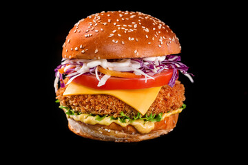chicken cheeseburger with lettuce tomato on a black background