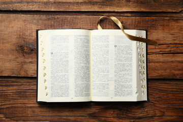 Open Bible on wooden table, top view. Christian religious book