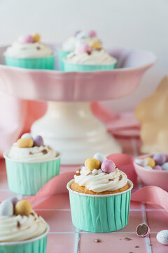 Easter egg food celebration image. Cupcakes, easter eggs, mini chocolate eggs and baking tools included in portrait frame. Pink and pastel colour spring colour theme.