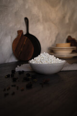Ceramic dishes with a dairy product on a kitchen wooden table.