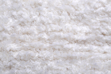 Soft white knitted fabric as background, top view