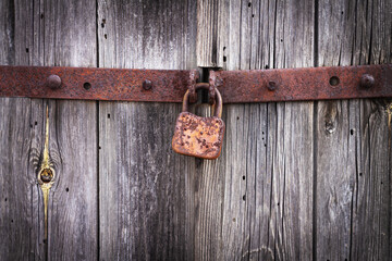 Rusty padlock on old vintage wooden door