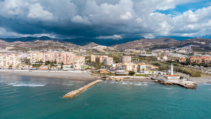 Drone perspective of costal city of Torrox situated in Malaga, Costa del Sol, Spain. Touristic travel destination. View of the promenade and beach area. The lighthouse of Torrox and the river. - obrazy, fototapety, plakaty