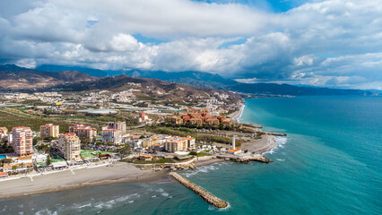 Drone perspective of costal city of Torrox situated in Malaga, Costa del Sol, Spain. Touristic travel destination. View of the promenade and beach area. The lighthouse of Torrox and the river. - obrazy, fototapety, plakaty