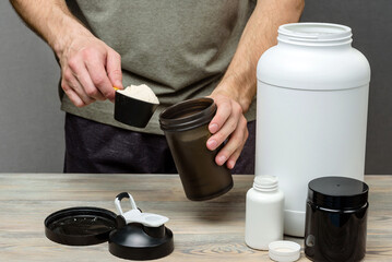 The athlete pours protein into a shaker. The concept of sports nutrition.