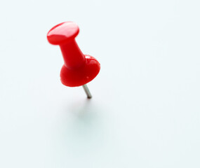 Single pushpin on white background