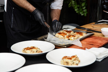 Chief serving potato gratin with chanterelles mushrooms and cheese in a restaurant