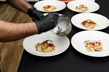 Chief serving potato gratin with chanterelles mushrooms and cheese in a restaurant