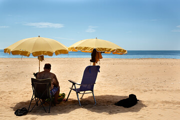 Hombre sentado en una silla en la playa.
